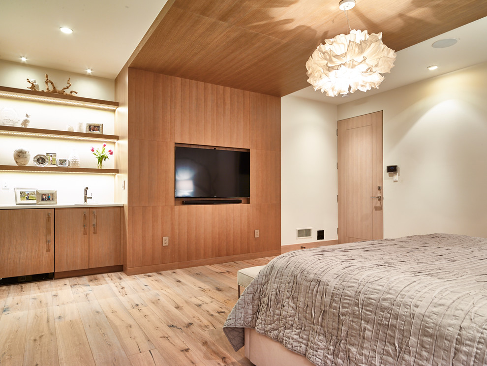This is an example of a large contemporary guest bedroom in Denver with white walls and light hardwood floors.