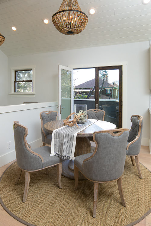 This is an example of a mid-sized beach style open plan dining in San Francisco with white walls and light hardwood floors.