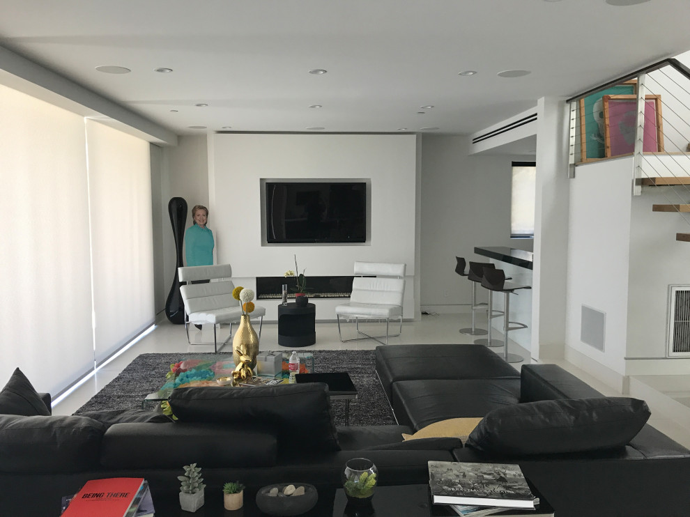 Design ideas for a large modern open concept family room in Los Angeles with white walls, marble floors, a standard fireplace, a metal fireplace surround, a wall-mounted tv and white floor.