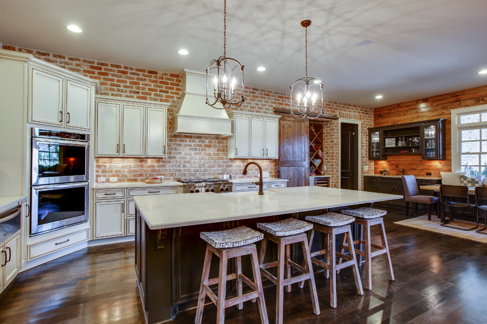 Inspiration for a transitional l-shaped dark wood floor open concept kitchen remodel in Nashville with quartz countertops, brick backsplash, stainless steel appliances and an island