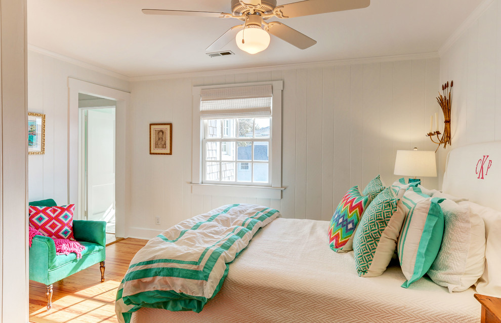 This is an example of a mid-sized beach style guest bedroom in Wilmington with white walls and light hardwood floors.