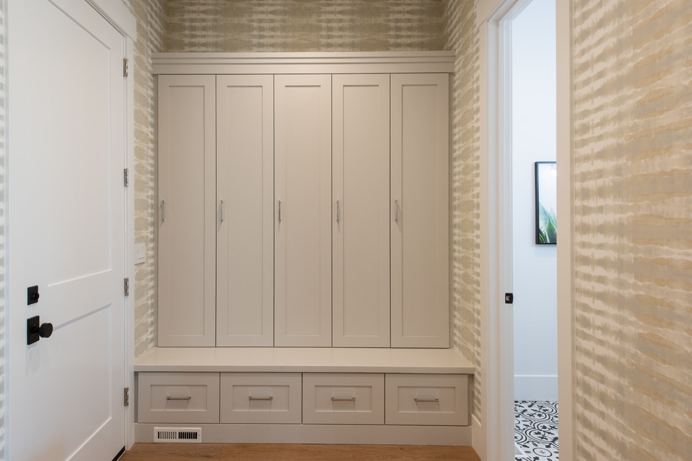 Design ideas for a mid-sized transitional mudroom in Salt Lake City with white walls, light hardwood floors, a single front door, a white front door and brown floor.
