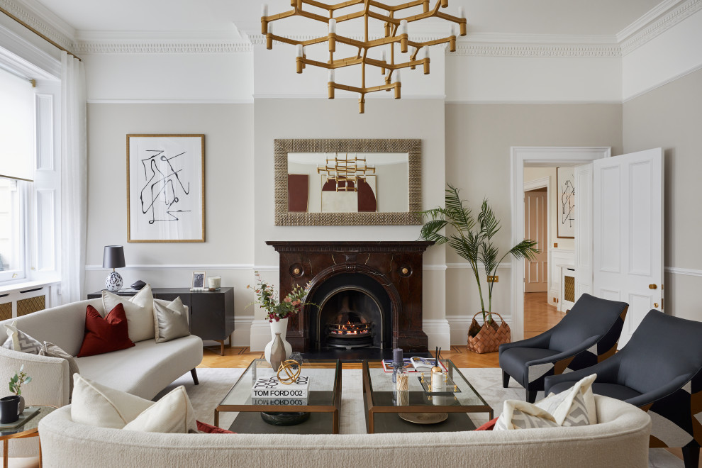 Classic enclosed living room in London with beige walls, medium hardwood flooring, a standard fireplace and brown floors.