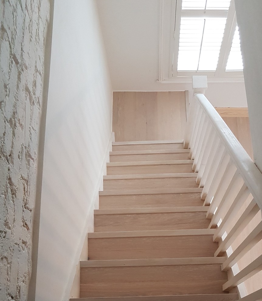 На фото: прямая деревянная лестница среднего размера в стиле кантри с деревянными ступенями и деревянными перилами с