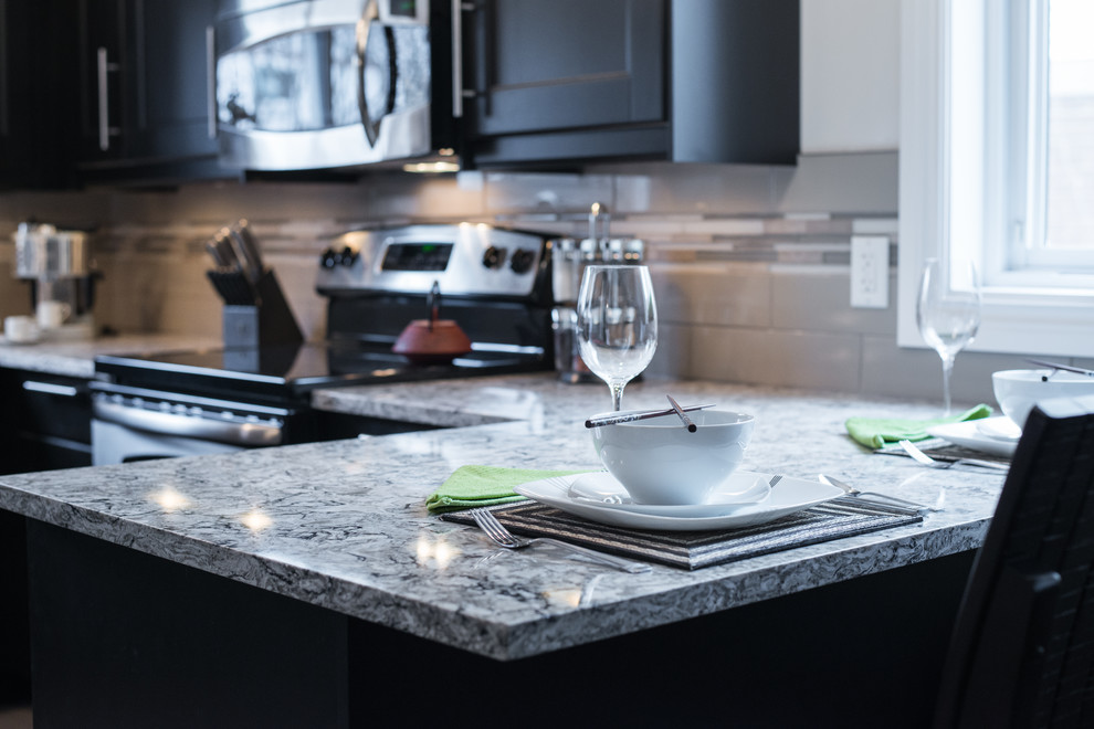 Example of a porcelain tile eat-in kitchen design in Ottawa with an undermount sink, recessed-panel cabinets, quartz countertops, glass tile backsplash and stainless steel appliances
