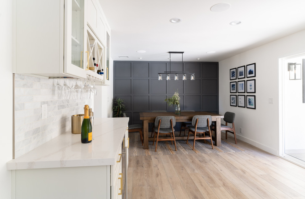 Immagine di una grande sala da pranzo aperta verso la cucina chic con pareti grigie, pavimento in vinile, pavimento marrone e boiserie