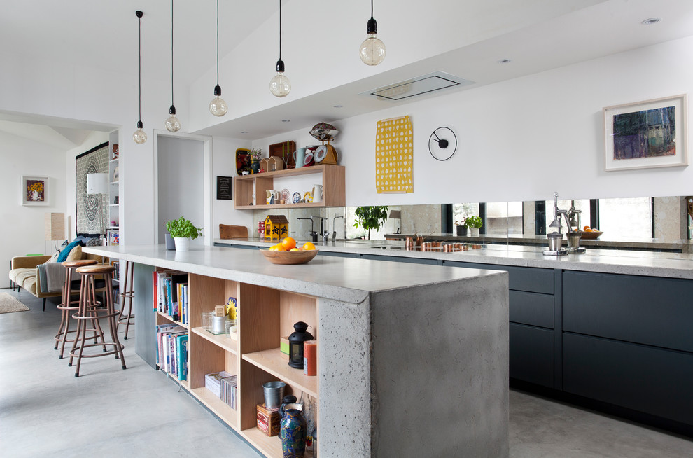 This is an example of a large contemporary open plan kitchen in Other with black cabinets, concrete benchtops, mirror splashback, concrete floors, with island, grey floor, grey benchtop and flat-panel cabinets.