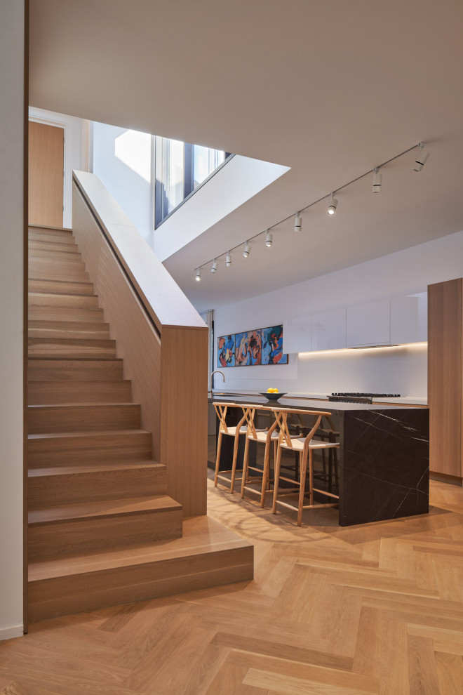 This is an example of a large modern wood straight wood railing staircase in Toronto with wood risers and wood walls.