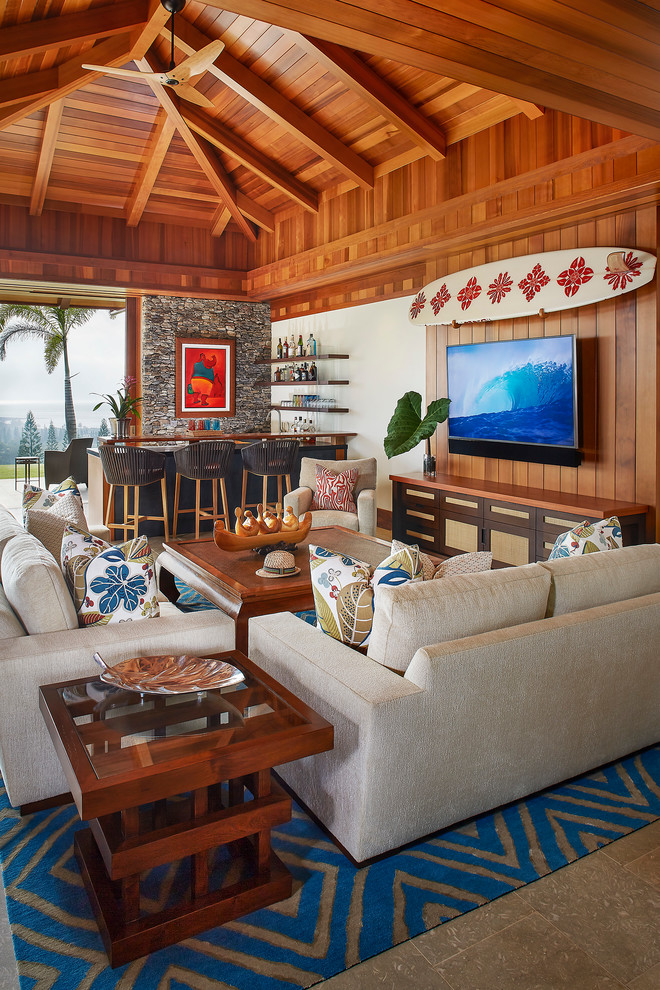 Inspiration for a large tropical open concept family room in Hawaii with no fireplace, a wall-mounted tv, a home bar, brown walls and brown floor.