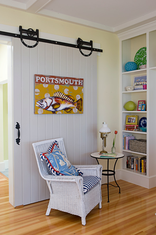 Inspiration for a beach style enclosed family room in Boston with beige walls and light hardwood floors.