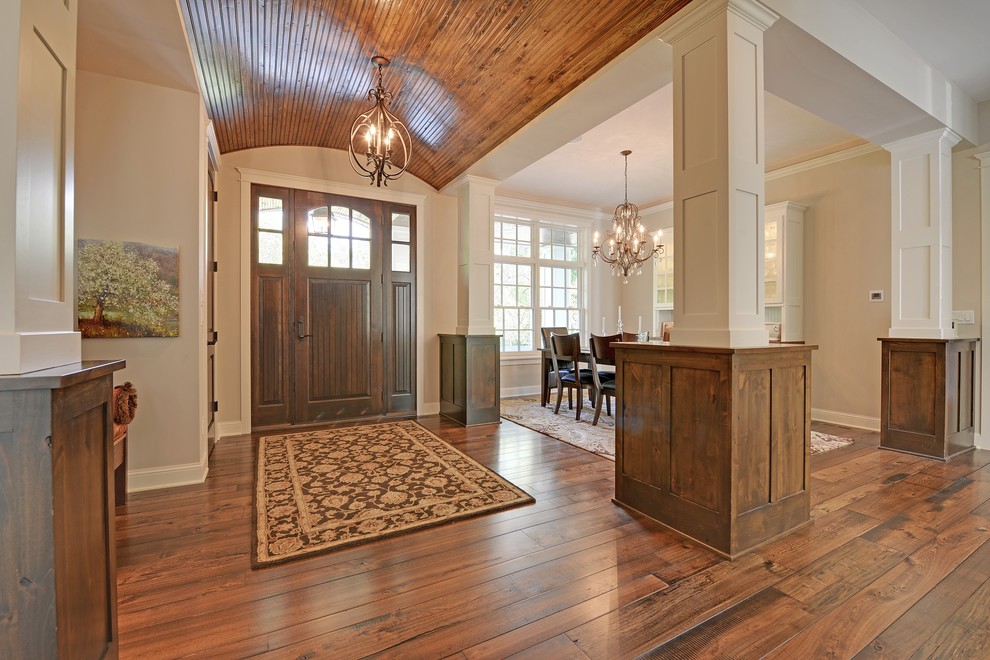 Inspiration for a traditional foyer in Minneapolis with beige walls, medium hardwood floors, a single front door and a medium wood front door.