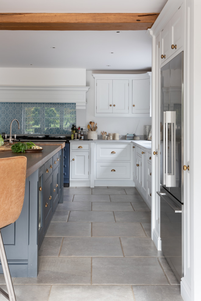Inspiration for a large traditional l-shaped eat-in kitchen in Surrey with a drop-in sink, shaker cabinets, white cabinets, wood benchtops, blue splashback, glass sheet splashback, stainless steel appliances, porcelain floors, with island, grey floor, brown benchtop and exposed beam.