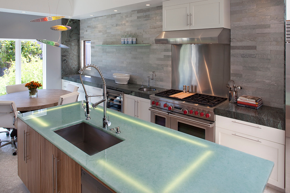 Large contemporary galley eat-in kitchen in San Francisco with an undermount sink, shaker cabinets, white cabinets, glass benchtops, green splashback, stone tile splashback, stainless steel appliances, marble floors and with island.