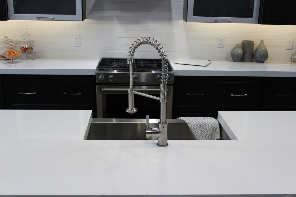 Inspiration for a mid-sized transitional galley medium tone wood floor eat-in kitchen remodel in Chicago with a farmhouse sink, recessed-panel cabinets, quartzite countertops, white backsplash, ceramic backsplash, stainless steel appliances and an island