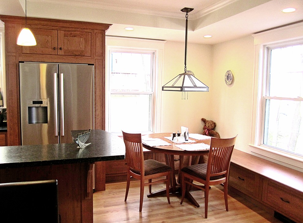 Mid-sized transitional single-wall eat-in kitchen photo with an undermount sink, recessed-panel cabinets, medium tone wood cabinets, granite countertops, black backsplash, stone slab backsplash and stainless steel appliances