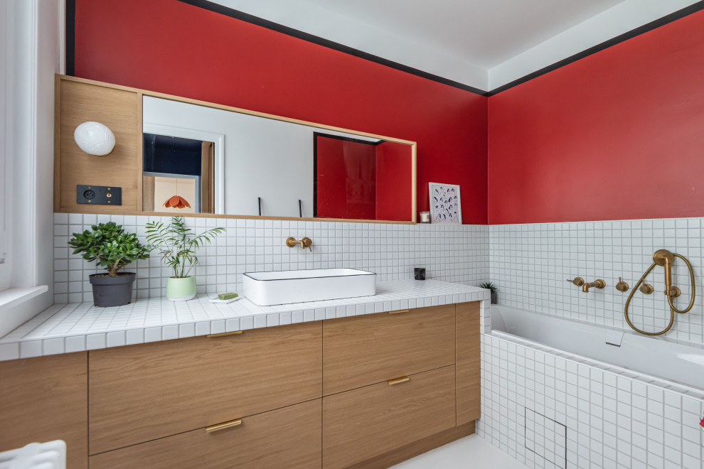 Contemporary bathroom in Lille with flat-panel cabinets, medium wood cabinets, an alcove bath, white tiles, red walls, a vessel sink, tiled worktops, white floors, white worktops, a single sink and a built in vanity unit.