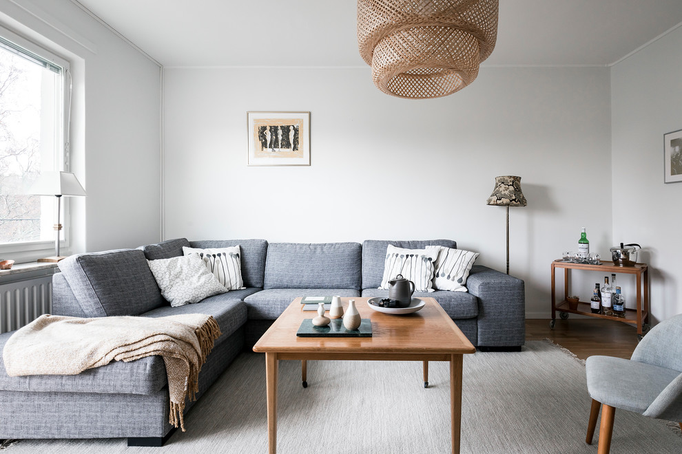 Photo of a mid-sized scandinavian living room in Stockholm with white walls, a home bar and no fireplace.
