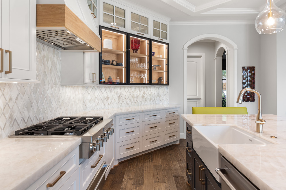 Example of a large transitional single-wall light wood floor and brown floor eat-in kitchen design in Houston with a farmhouse sink, recessed-panel cabinets, white cabinets, quartzite countertops, white backsplash, mosaic tile backsplash, stainless steel appliances, an island and white countertops
