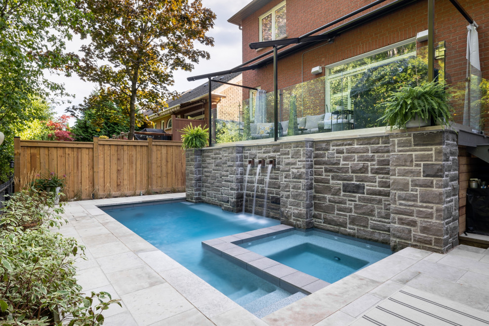 Пример оригинального дизайна: маленький прямоугольный ландшафтный бассейн на заднем дворе в стиле неоклассика (современная классика) с покрытием из каменной брусчатки для на участке и в саду