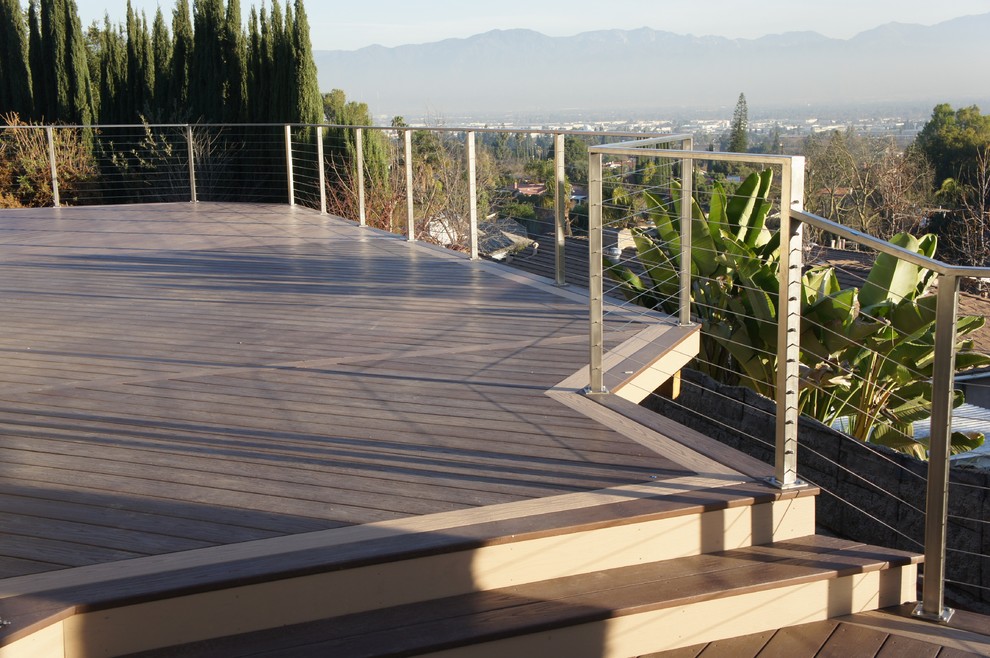 Large contemporary backyard full sun outdoor sport court in Los Angeles with a retaining wall and decking for summer.