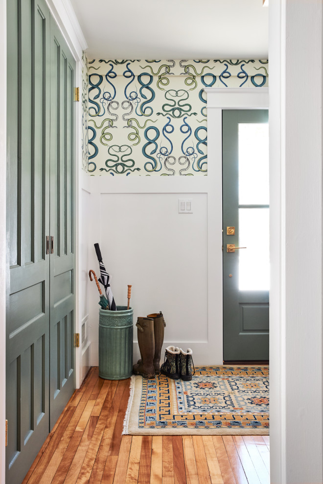 Inspiration for a small front door in New York with multi-coloured walls, medium hardwood floors, a single front door, a glass front door, brown floor and wallpaper.