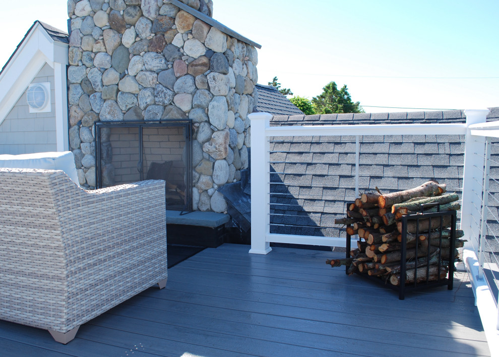 Diseño de terraza costera de tamaño medio sin cubierta en azotea con chimenea y barandilla de cable