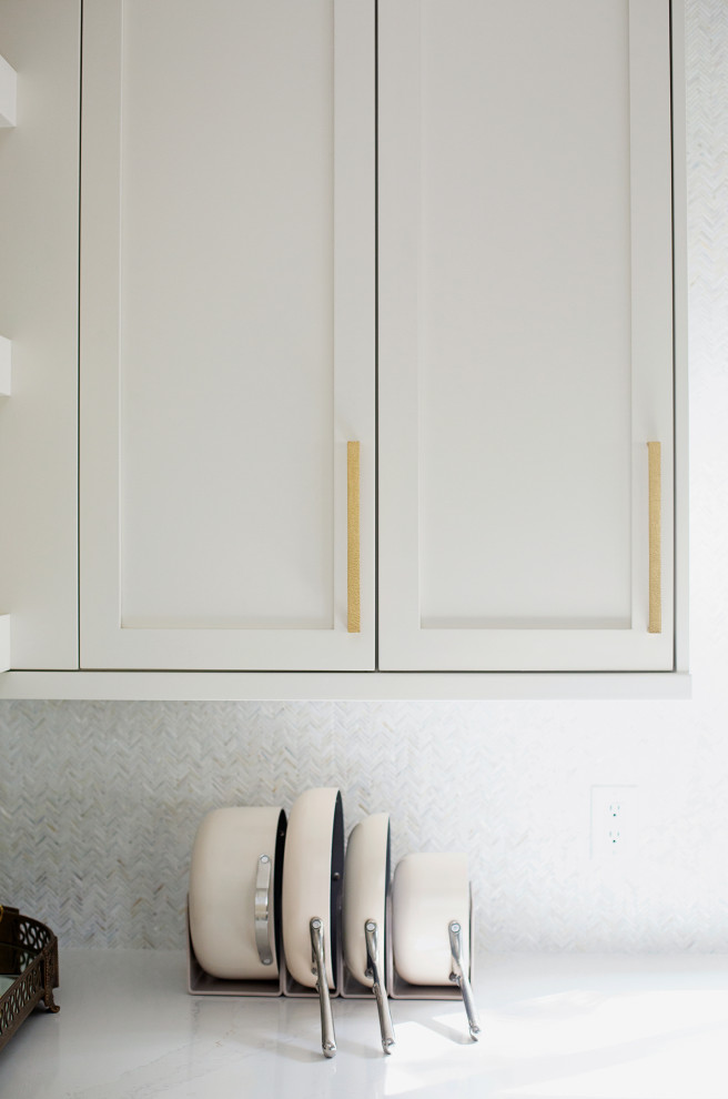 Modelo de cocina clásica grande con fregadero sobremueble, armarios estilo shaker, puertas de armario blancas, encimera de cuarcita, salpicadero blanco, salpicadero de azulejos de cerámica, electrodomésticos de acero inoxidable, suelo de mármol, una isla, suelo blanco y encimeras blancas