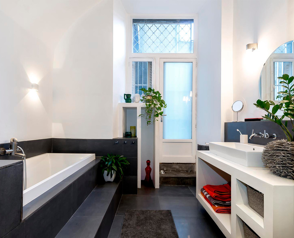 Inspiration for a mid-sized contemporary master bathroom in Clermont-Ferrand with a vessel sink, a trough sink, open cabinets, white cabinets, a drop-in tub, gray tile and white walls.