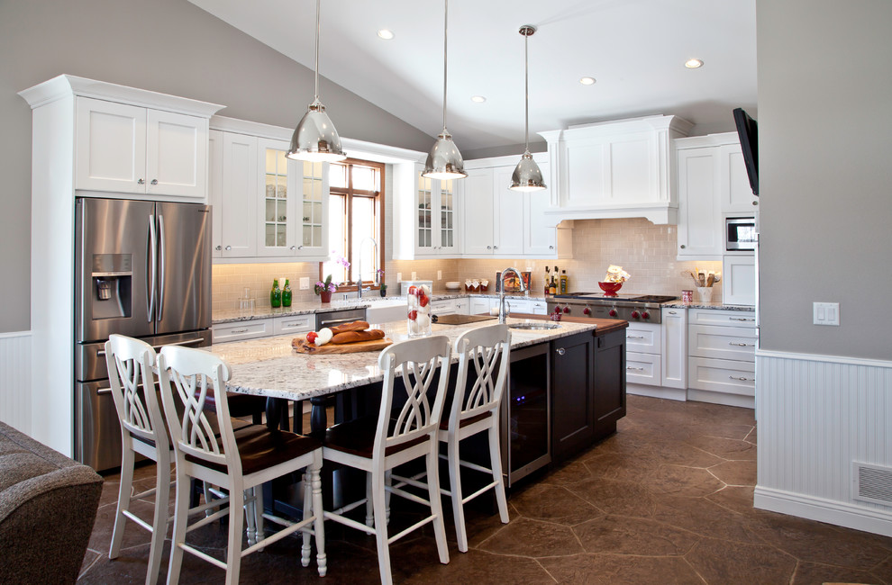 Large transitional u-shaped slate floor and brown floor open concept kitchen photo with a farmhouse sink, shaker cabinets, white cabinets, granite countertops, yellow backsplash, subway tile backsplash, stainless steel appliances and two islands