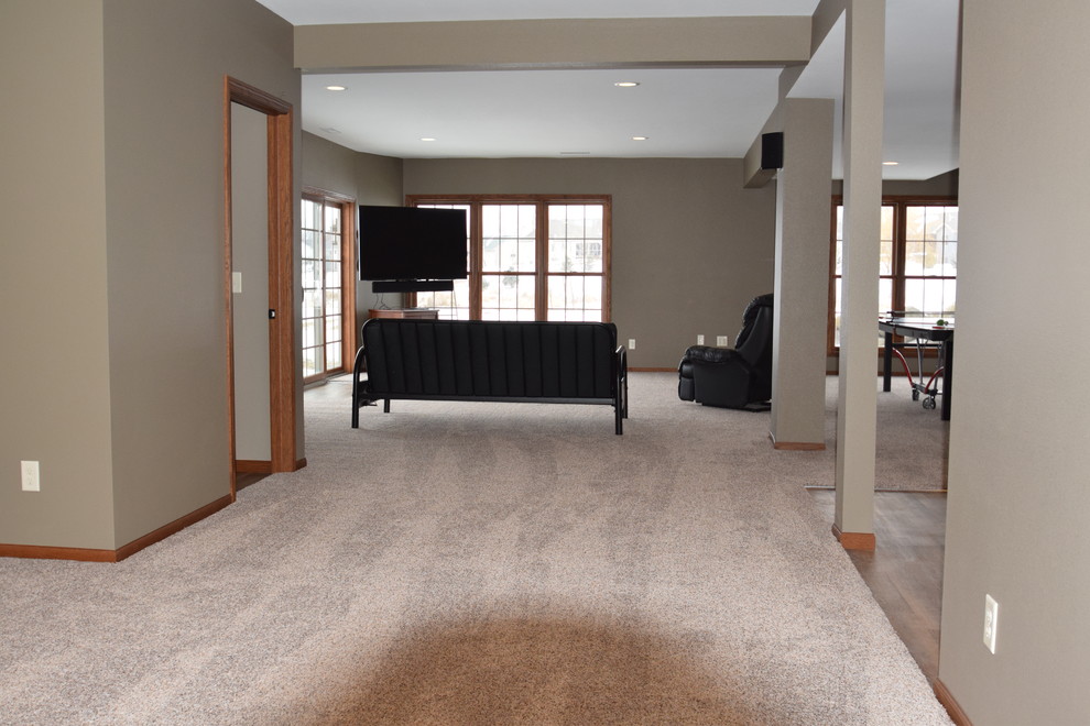 Inspiration for a mid-sized transitional walk-out carpeted basement remodel with beige walls