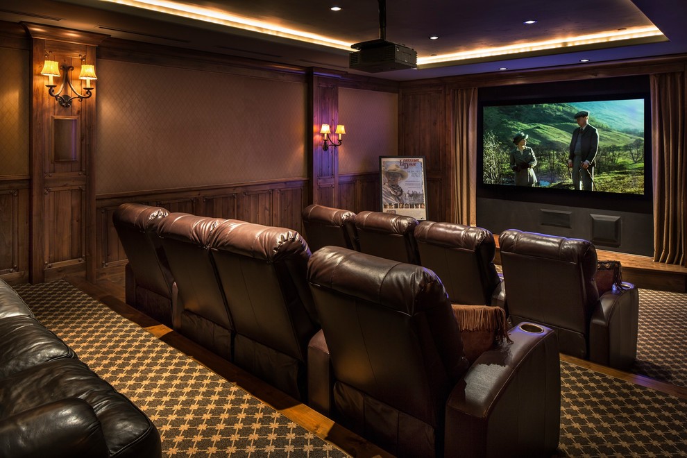 This is an example of a large country enclosed home theatre in Santa Barbara with brown walls, carpet and a projector screen.