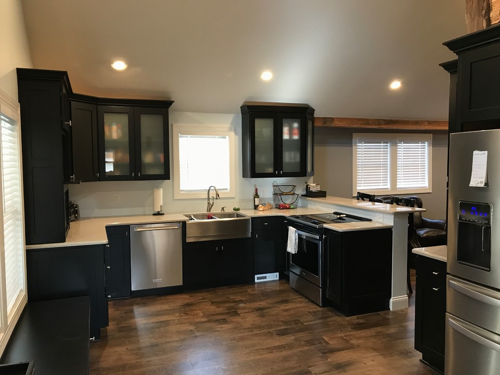 Mid-sized transitional u-shaped open plan kitchen in Other with an undermount sink, shaker cabinets, black cabinets, quartz benchtops, stainless steel appliances, a peninsula and white benchtop.