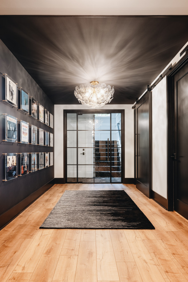 Idée de décoration pour un grand couloir tradition avec un mur noir, parquet clair et un sol beige.