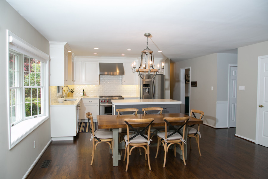 This is an example of a transitional eat-in kitchen in Philadelphia with recessed-panel cabinets, white cabinets, granite benchtops, white splashback, subway tile splashback, stainless steel appliances, medium hardwood floors and with island.
