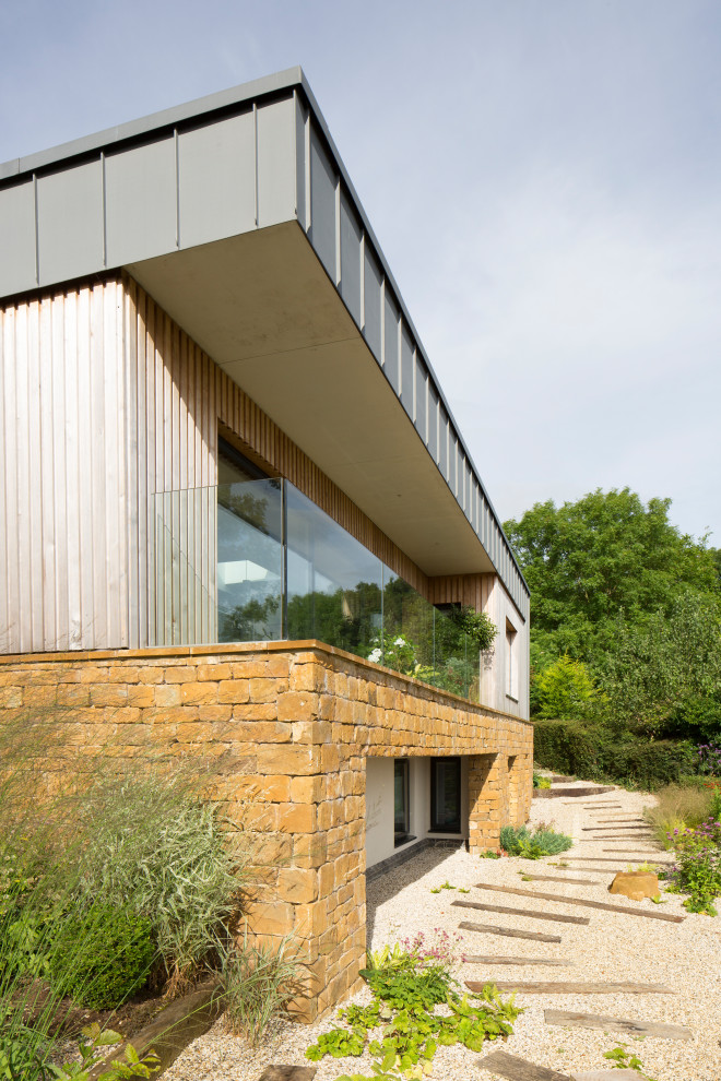 Photo of a contemporary two floor detached house in West Midlands with mixed cladding and a flat roof.