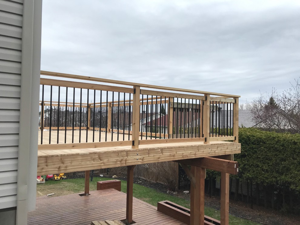 Walk-out red cedar deck with black round spindles