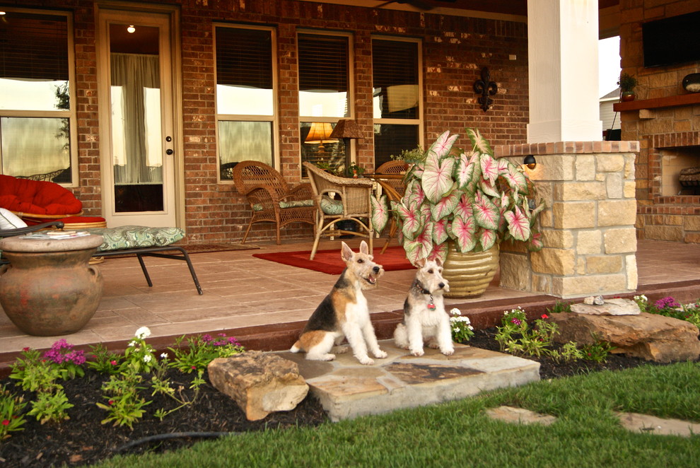 Large elegant backyard stamped concrete patio photo in Houston with a fire pit and a roof extension