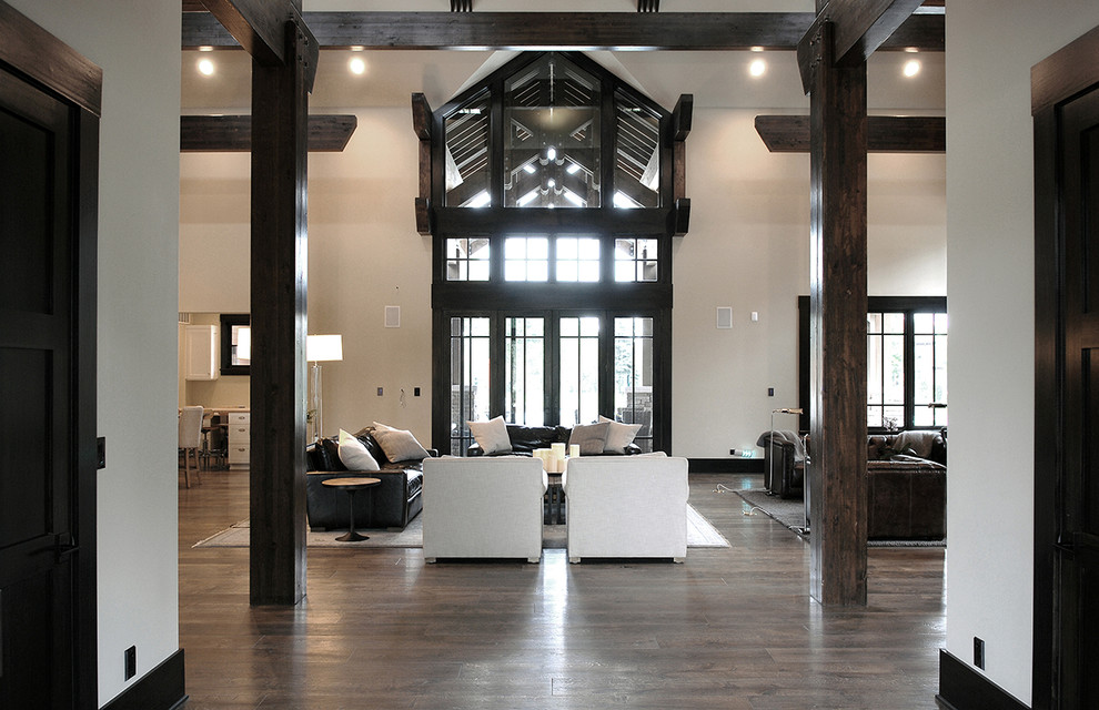 Esempio di un ampio soggiorno industriale aperto con sala formale, pareti bianche, pavimento in legno massello medio, pavimento marrone e travi a vista