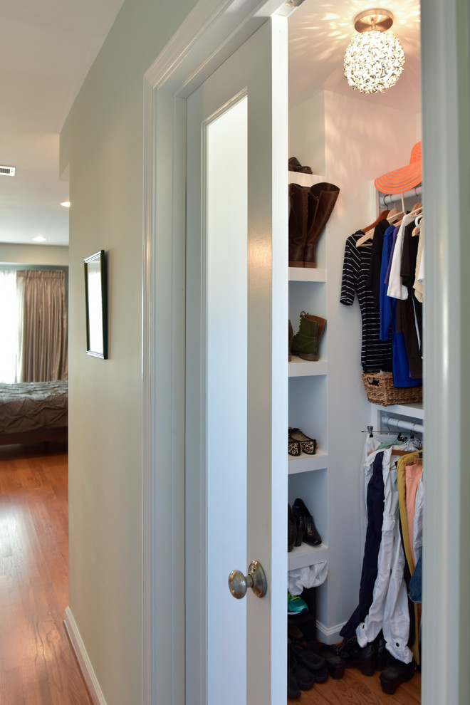 Design ideas for a mid-sized transitional gender-neutral built-in wardrobe in DC Metro with open cabinets, white cabinets, medium hardwood floors and brown floor.