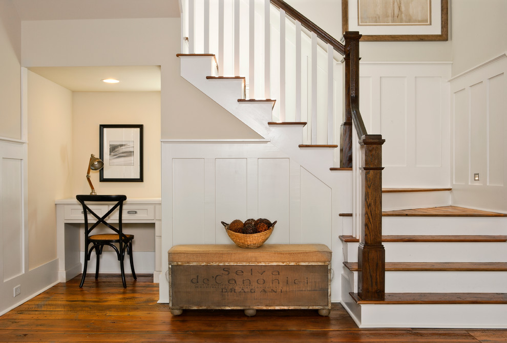 This is an example of a mid-sized beach style wood u-shaped staircase in Charleston.