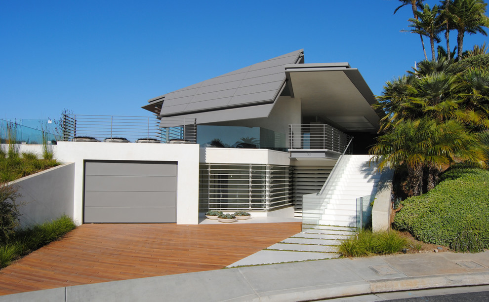 Photo of a large contemporary grey house exterior in Orange County with mixed siding and a metal roof.