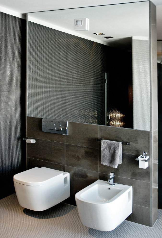 Ispirazione per una grande stanza da bagno con doccia design con vasca da incasso, WC sospeso, pavimento con piastrelle a mosaico, pavimento grigio, un lavabo e mobile bagno sospeso