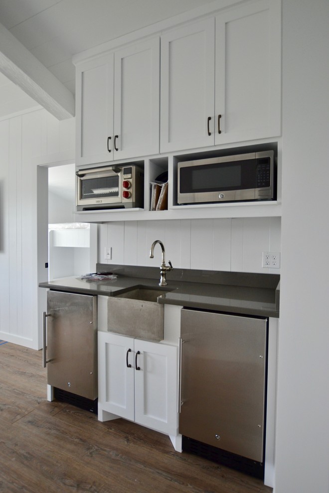 Small transitional single-wall medium tone wood floor, brown floor and exposed beam kitchen pantry photo in Austin with an undermount sink, shaker cabinets, white cabinets, granite countertops, white backsplash, wood backsplash, stainless steel appliances, no island and brown countertops