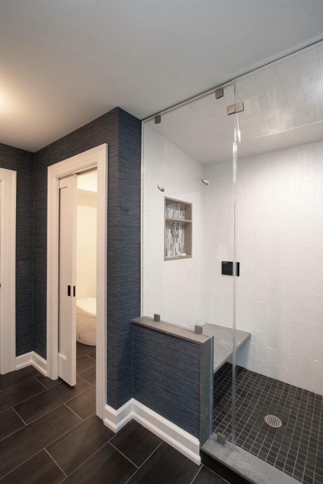 ニューヨークにある高級な広いトランジショナルスタイルのおしゃれなマスターバスルーム (シェーカースタイル扉のキャビネット、淡色木目調キャビネット、アルコーブ型シャワー、ビデ、白いタイル、セラミックタイル、青い壁、磁器タイルの床、壁付け型シンク、珪岩の洗面台、黒い床、開き戸のシャワー、マルチカラーの洗面カウンター、トイレ室、洗面台2つ、造り付け洗面台、壁紙) の写真