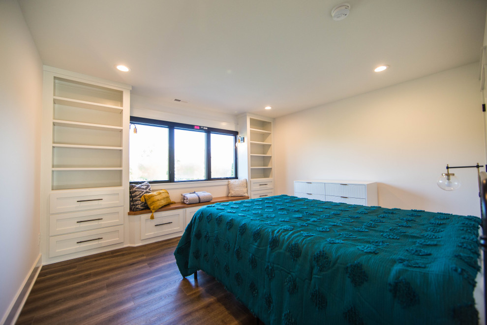 Foto di una grande camera da letto design con pareti beige, pavimento in laminato e pavimento marrone