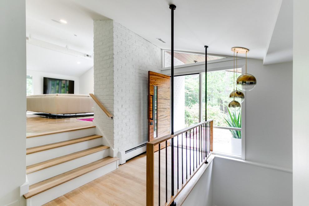 Small midcentury wood straight staircase in Richmond with mixed railing and brick walls.