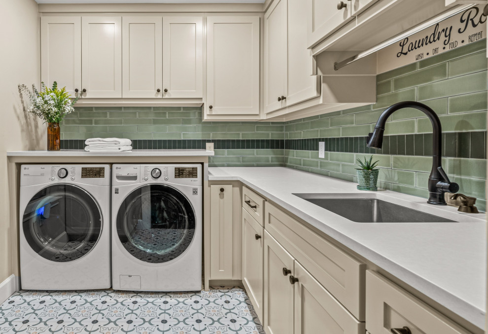 Farmhouse l-shaped beige floor laundry room photo in Dallas with green backsplash, an undermount sink, shaker cabinets, beige cabinets, subway tile backsplash, green walls, a side-by-side washer/dryer and white countertops