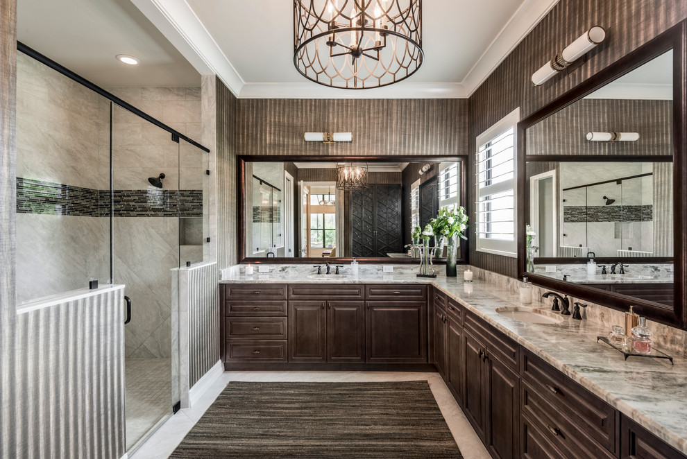 This is an example of a mid-sized transitional master bathroom in Miami with raised-panel cabinets, dark wood cabinets, an alcove shower, gray tile, multi-coloured tile, matchstick tile, an undermount sink, a hinged shower door, a one-piece toilet, brown walls, marble benchtops and beige floor.