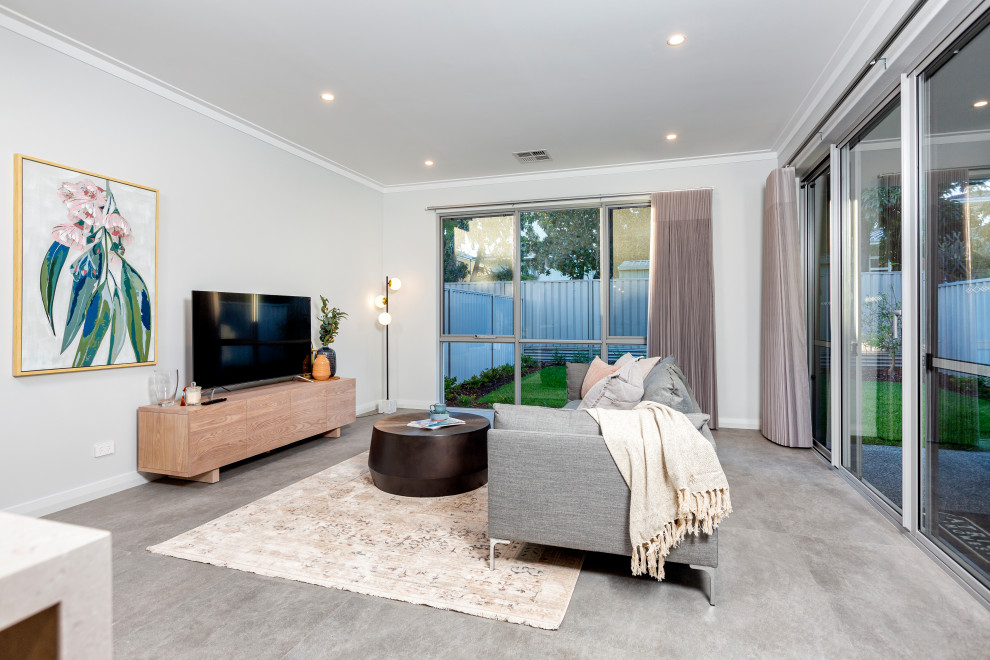 Идея дизайна: открытая гостиная комната в современном стиле с серыми стенами, ковровым покрытием, отдельно стоящим телевизором и бежевым полом