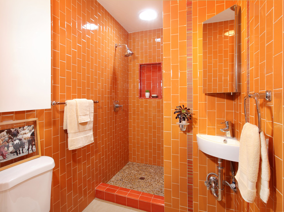 Design ideas for an eclectic bathroom in Los Angeles with a wall-mount sink, orange tile, pebble tile floors and orange walls.